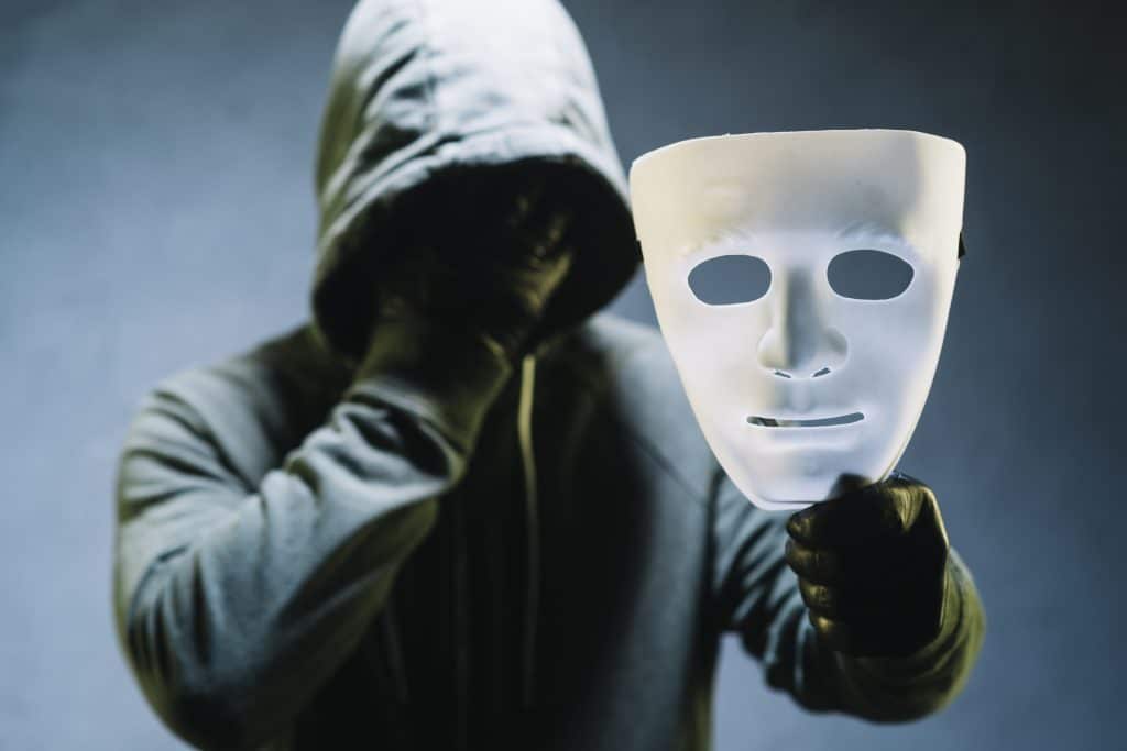 deep fake AI – oszust trzymający maskę